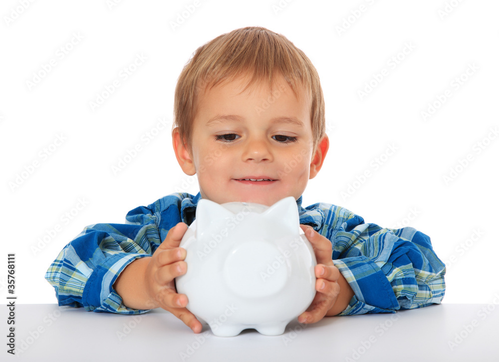 Kleiner Junge schaut stolz auf sein Sparschwein Kleiner Junge schaut stolz auf sein Sparschwein