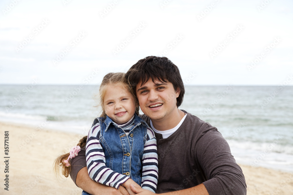 Father and daughter at the beach in fall.