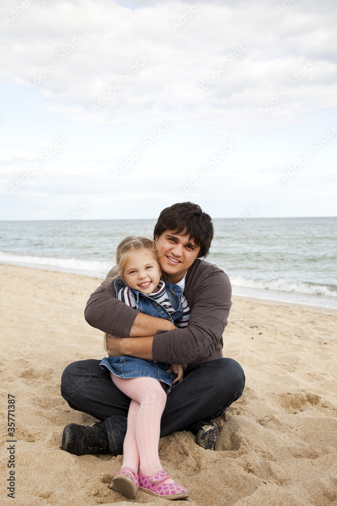 Father and daughter at the beach in fall.