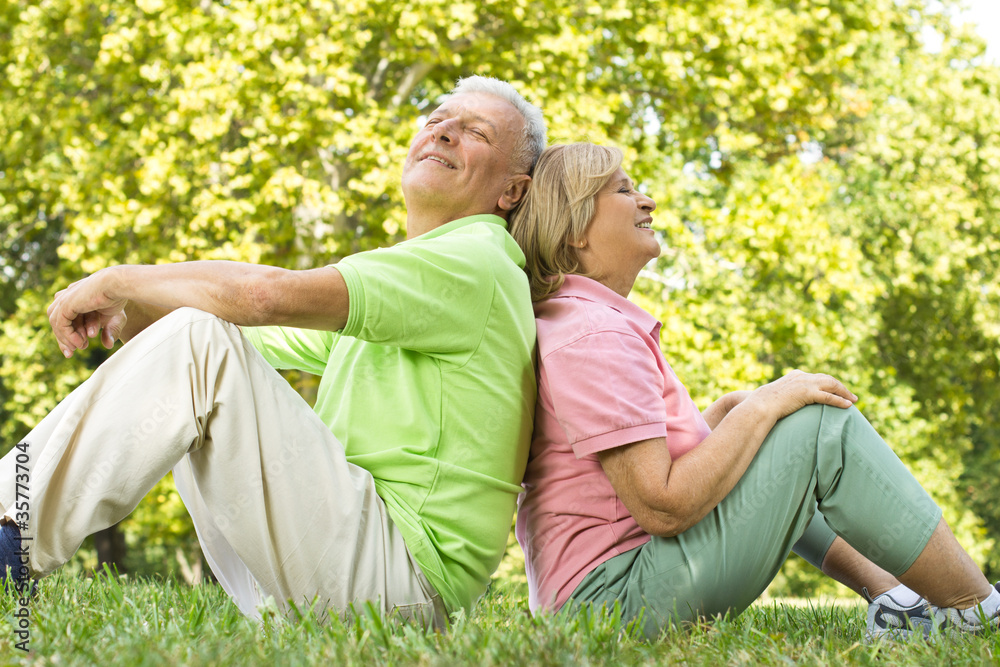 Happy senior couple sitting on grass Happy senior couple sitting on grass