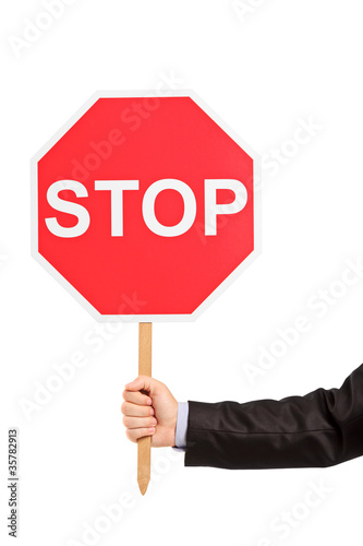 A hand holding a traffic sign stop