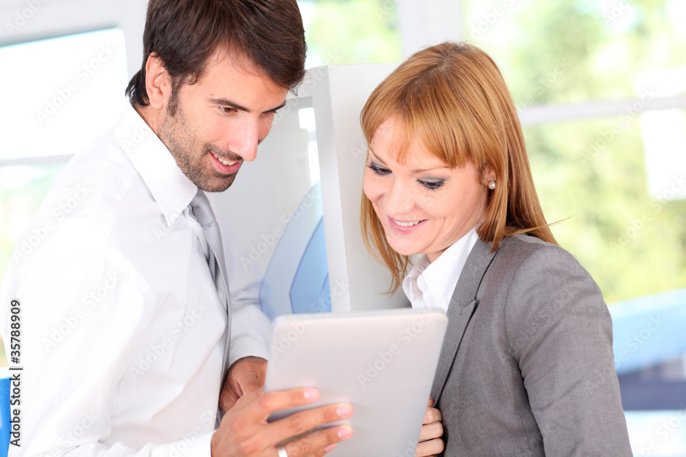 Business people in office using electronic tablet Business people in office using electronic tablet