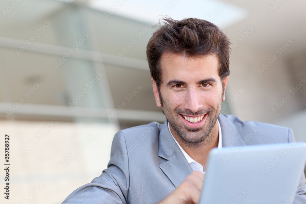 Portrait of smiling man using electronic tablet outside Portrait of smiling man using electronic tablet outside