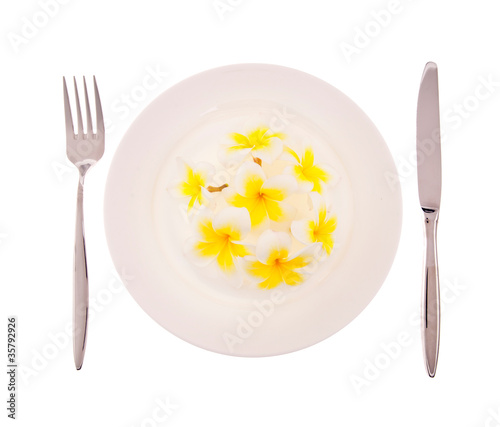 Natural concept, flowers on white plate with fork and knif