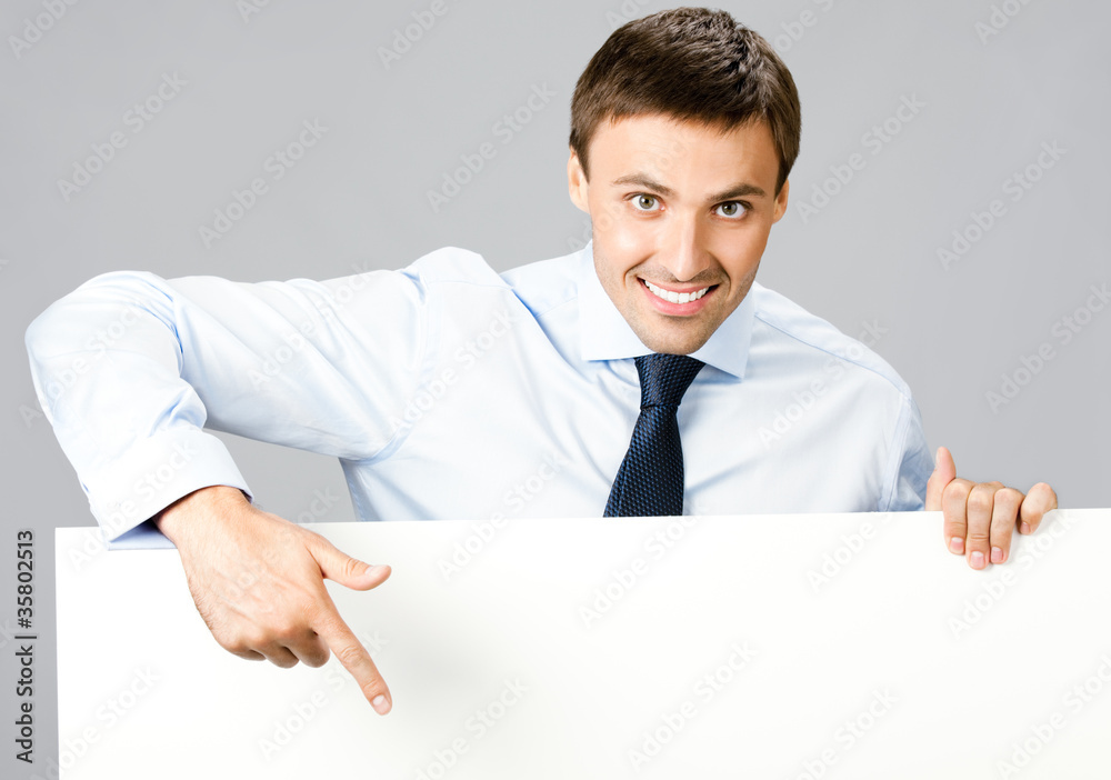 Business man showing blank signboard, over gray Business man showing blank signboard, over gray