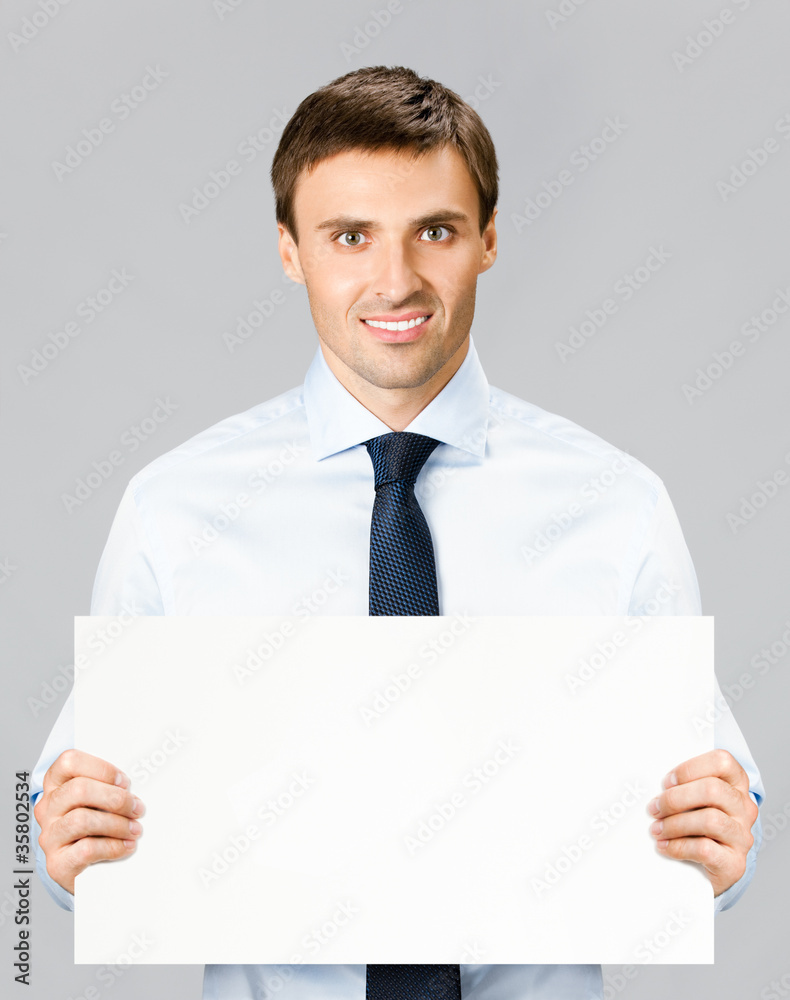 Business man showing blank signboard, over gray Business man showing blank signboard, over gray