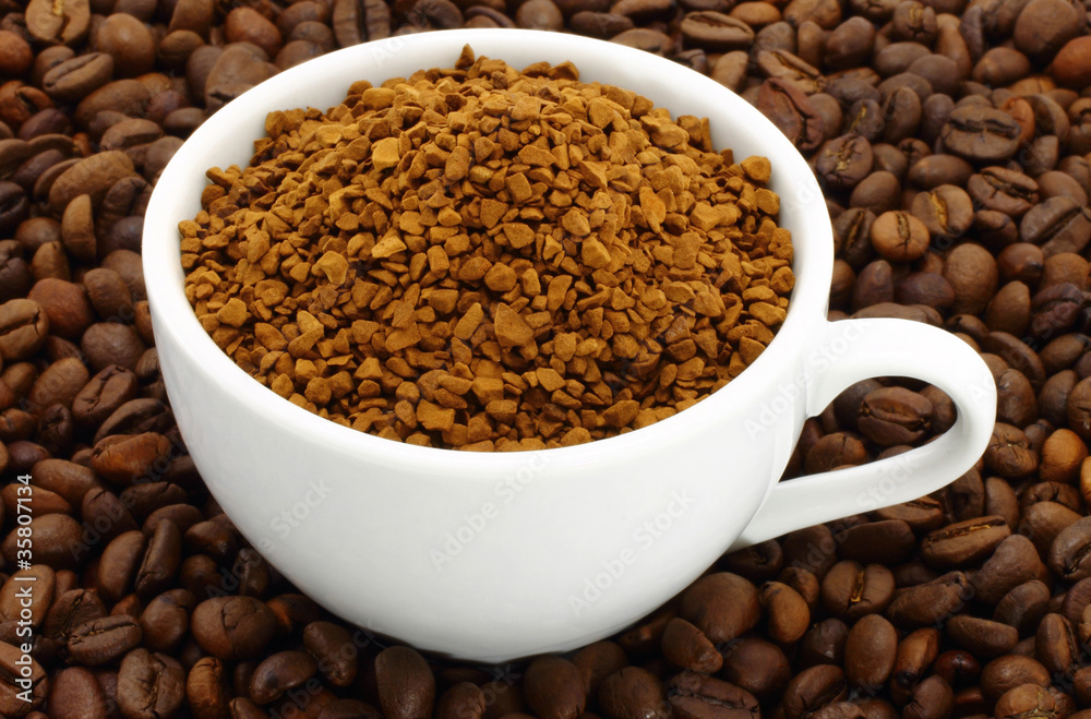 Cup of ground coffee on a coffee beans background Cup of ground coffee on a coffee beans background