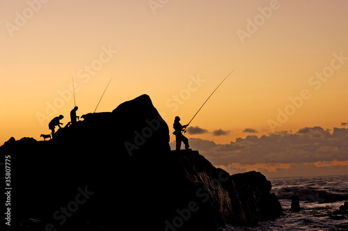 A silhouette of fishermen at dawn