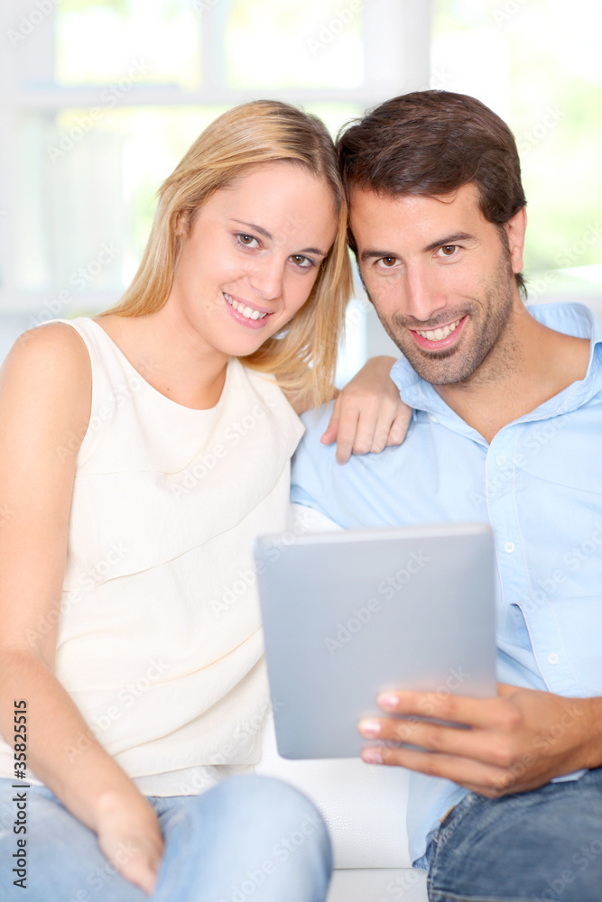 Young couple using electronic tablet at home Young couple using electronic tablet at home