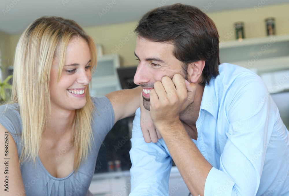 Happy young couple standing in home kitchen Happy young couple standing in home kitchen