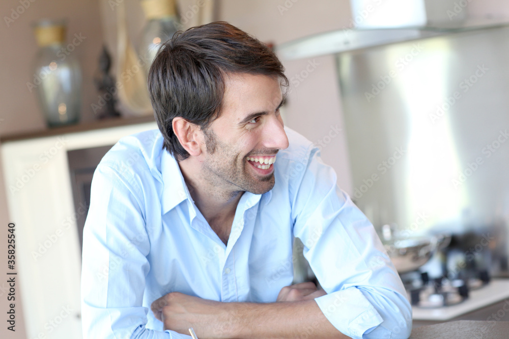 Fototapeta premium Smiling man standing in domestic kitchen