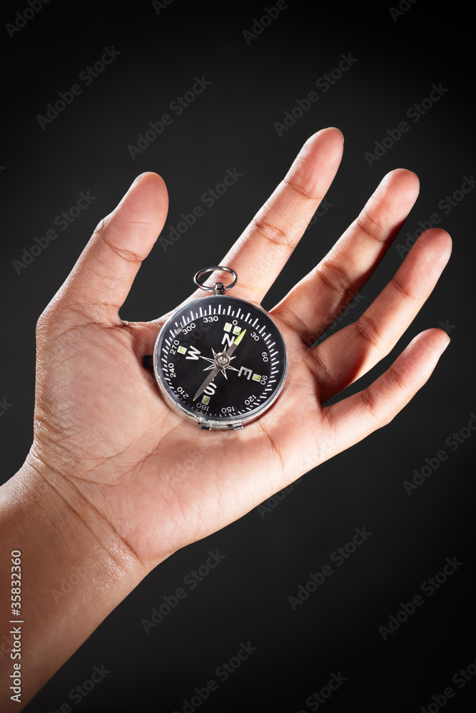 Hand holding compass Hand holding compass