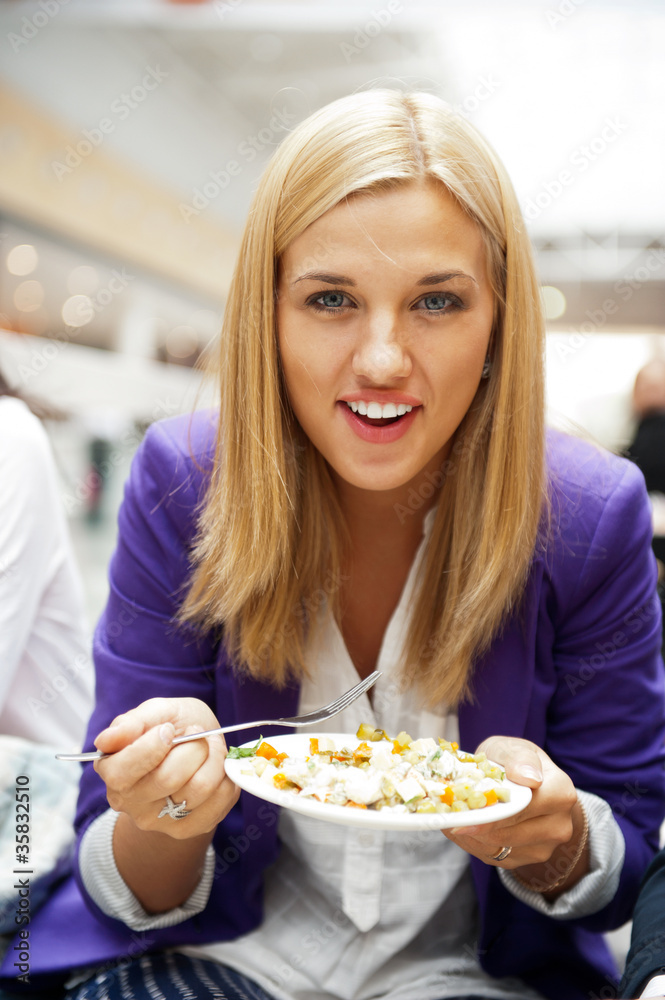 Closeup portrait of an attractive young woman eating fruit salad Closeup portrait of an attractive young woman eating fruit salad