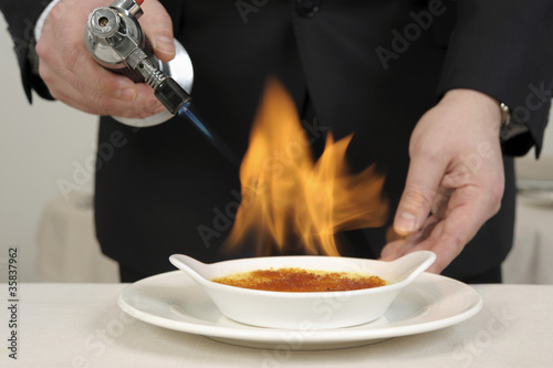 Caraméliser une crème brûlée au chalumeau photo