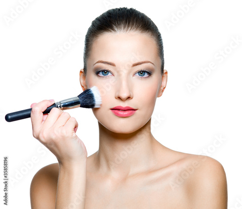 Beautiful sexy woman doing make-up on face