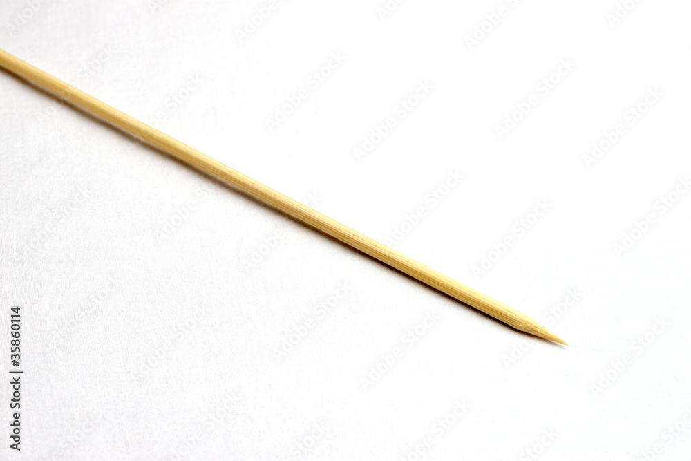 Single wooden bamboo skewer laying on white background Single wooden bamboo skewer laying on white background