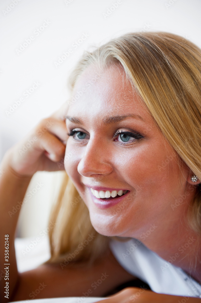 Portrait of beautiful smiling woman on bed at bedroom watching t Portrait of beautiful smiling woman on bed at bedroom watching t