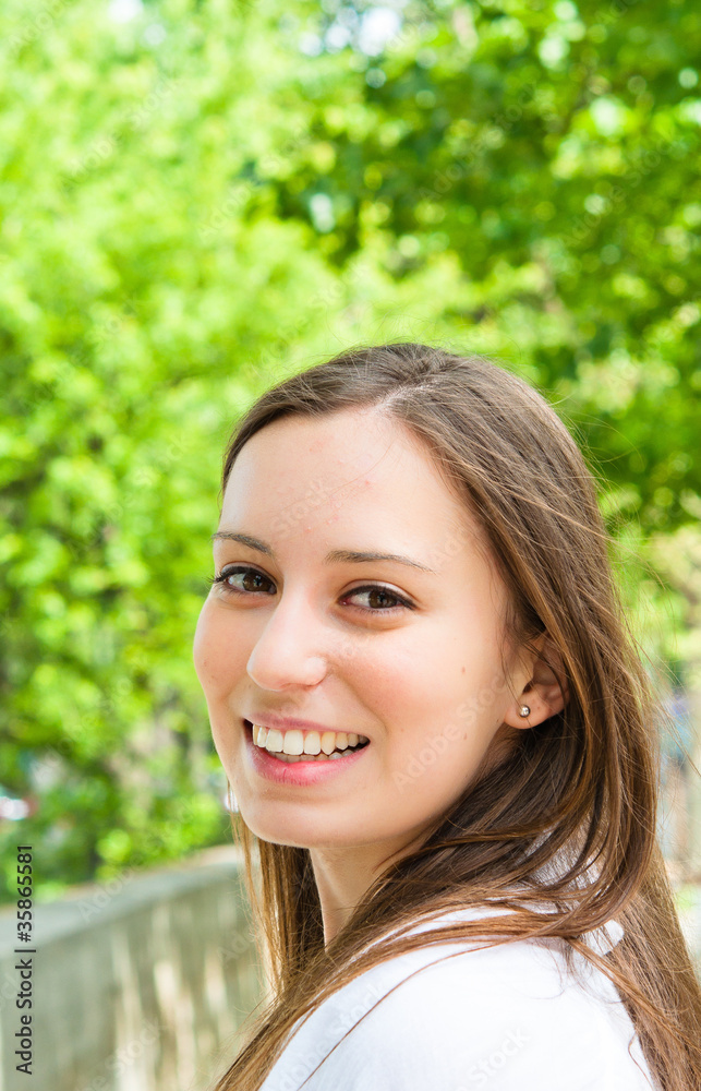 beautiful attractive young woman smiling while looking back beautiful attractive young woman smiling while looking back