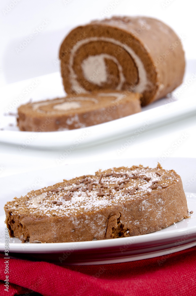 Biscuitrolle mit Schokostreusel und Vanillezucker auf einem Tell Biscuitrolle mit Schokostreusel und Vanillezucker auf einem Tell