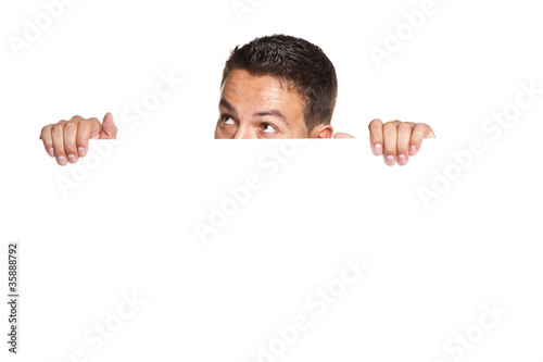 man peeking behind empty white billboard