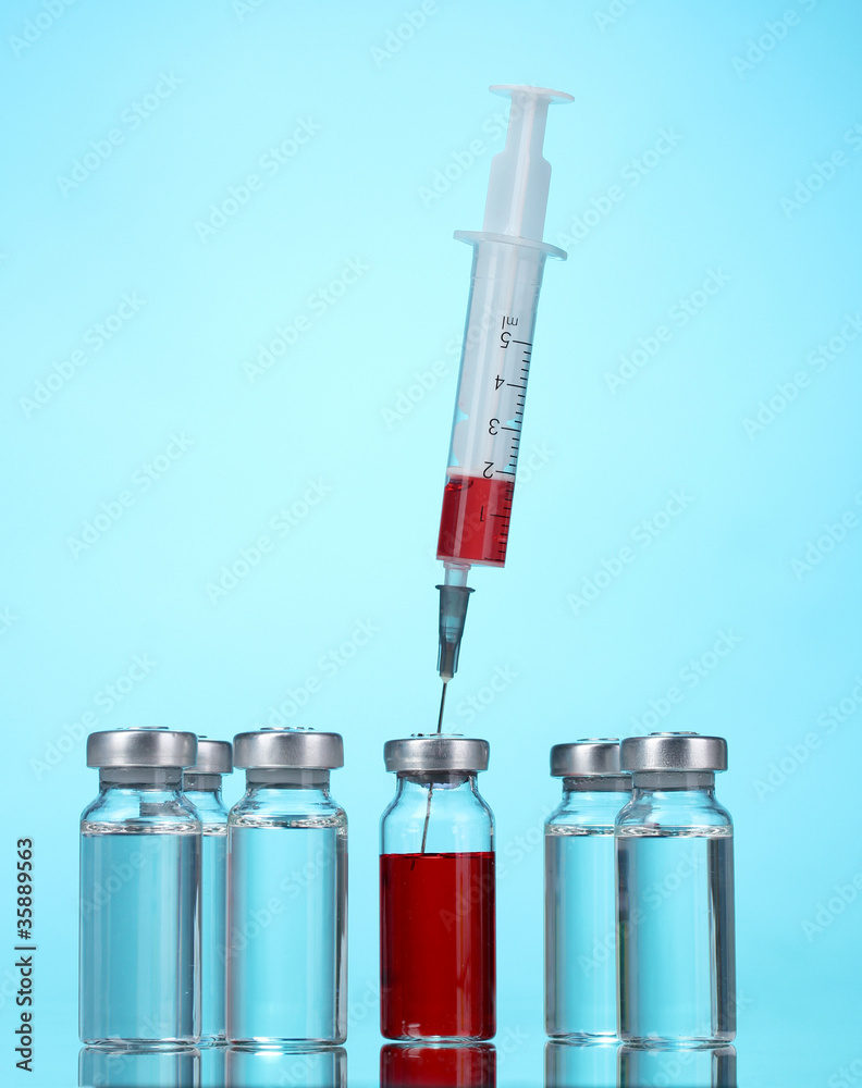 medical ampoules and syringe on blue background medical ampoules and syringe on blue background
