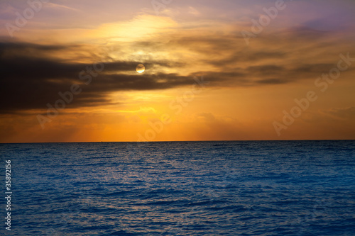 golden sunrise with sun and clouds over sea