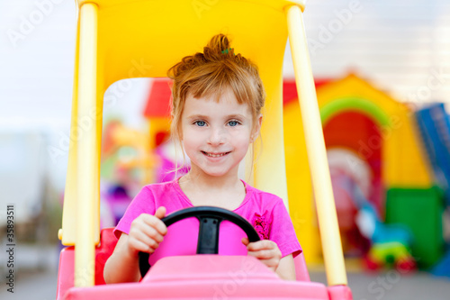 blond children girl driving toy car