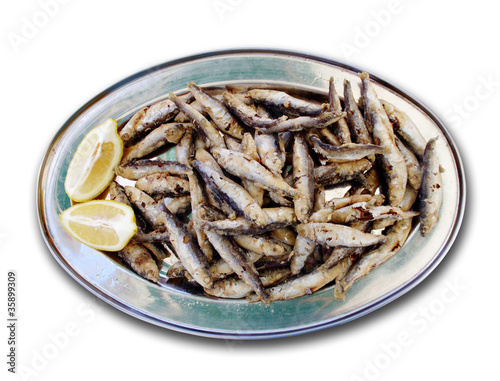 Fried sprats on metal plate