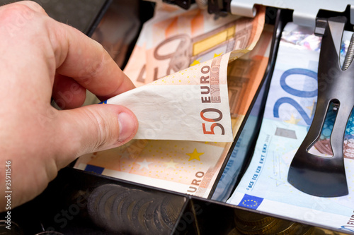 Hand giving change in euro from the till photo