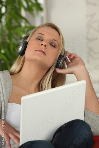 Young woman listening to music on her laptop