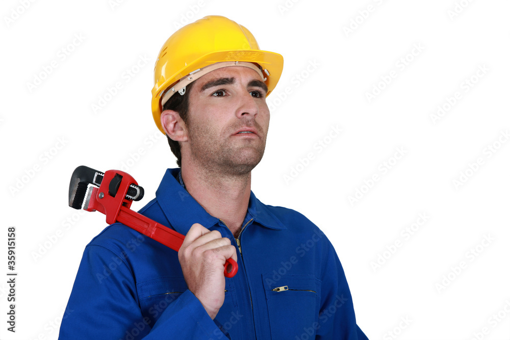 pensive electrician holding adjustable spanner pensive electrician holding adjustable spanner
