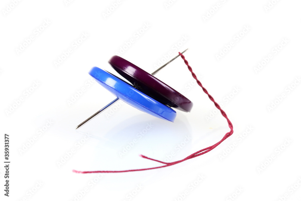 Bright sewing buttons and needle with cotton isolated on white Bright sewing buttons and needle with cotton isolated on white