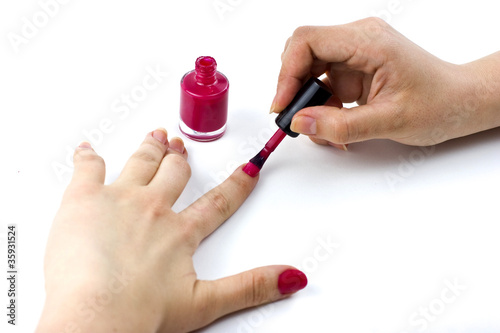 woman applying pink nail polish