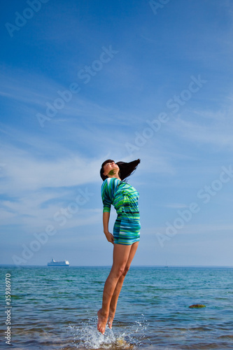 beautiful girl jumping out of sea