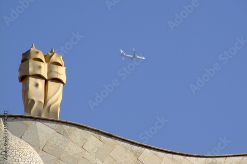 Canvastavla Schornsteine der Casa Mila, Barcelona, mit Flugzeug
