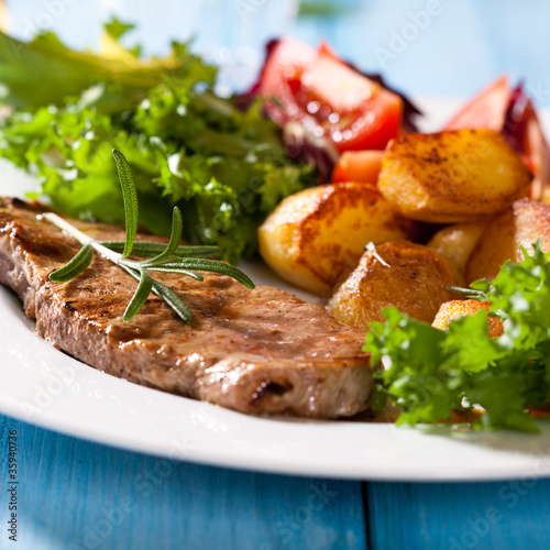 Grilled beefsteak with oven baked potatoes and salad