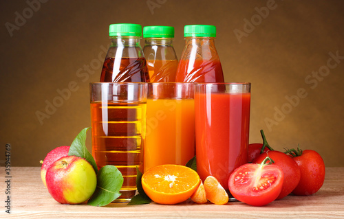 Different juices and fruits on wooden table