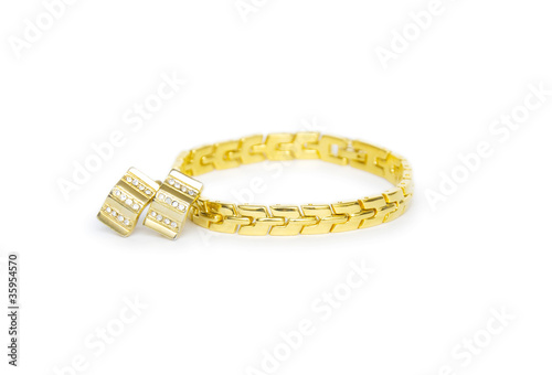 Golden bracelet with ear-rings isolated on white background