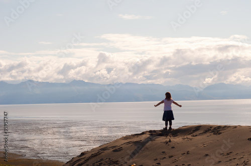 Girl on Cliff with Arms Spread