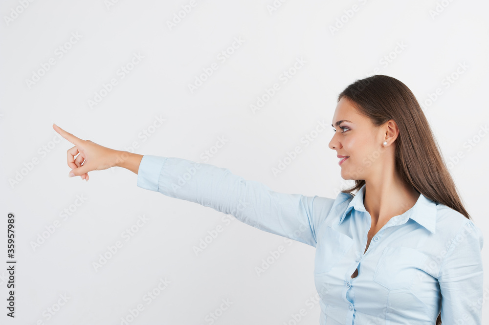 Happy smiling young business woman showing blank area for sign o Happy smiling young business woman showing blank area for sign o