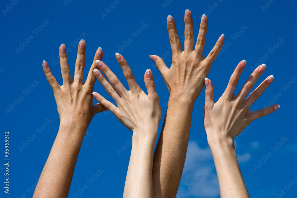 Raised hands on blue sky background
