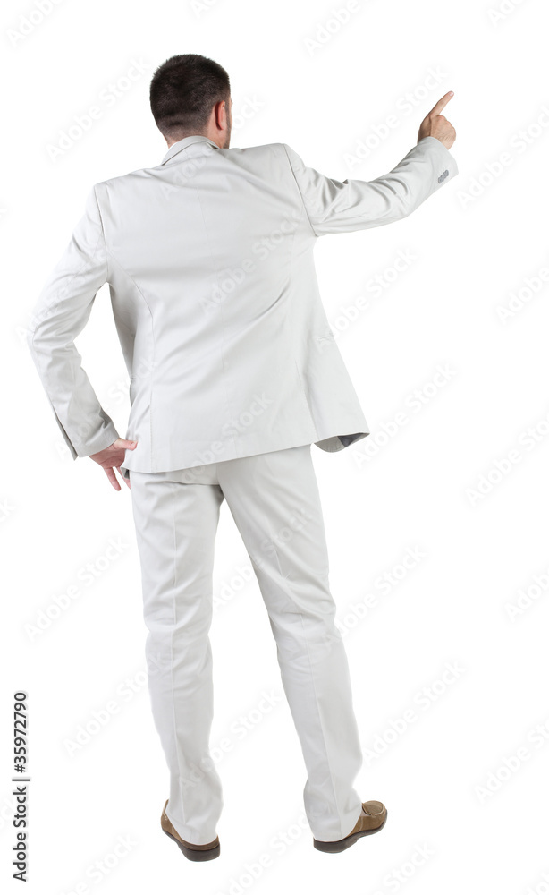 Businessman pointing at wall. rear view. Businessman pointing at wall. rear view.