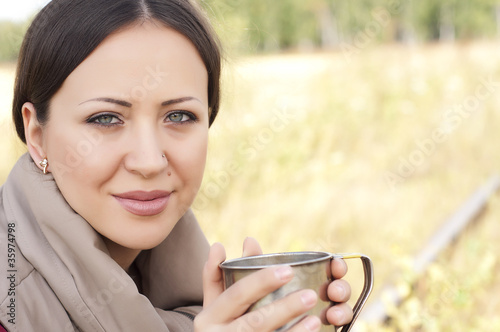 portrait of a beautiful girl, drinking from a cup photo