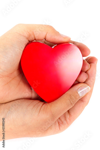 Female hands taking care of red heart