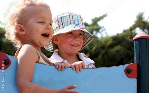 Two boys are laughing aloud and looking forward