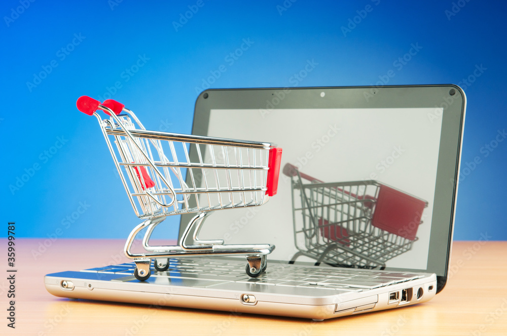 Shopping online with computer and cart Shopping online with computer and cart