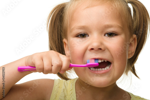 Little girl is cleaning teeth using toothbrush