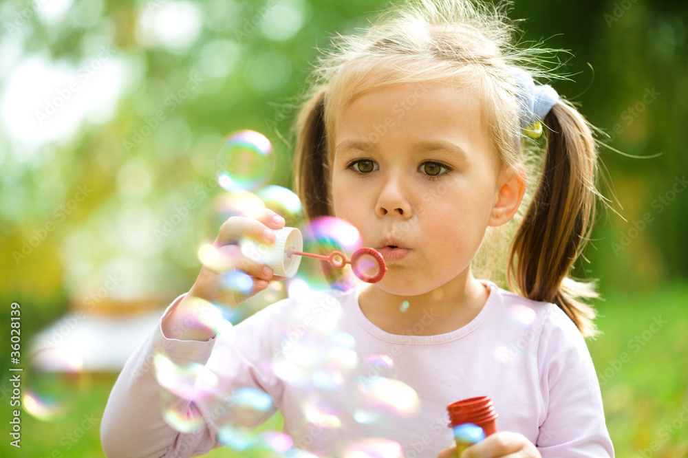 Little girl is blowing a soap bubbles Little girl is blowing a soap bubbles