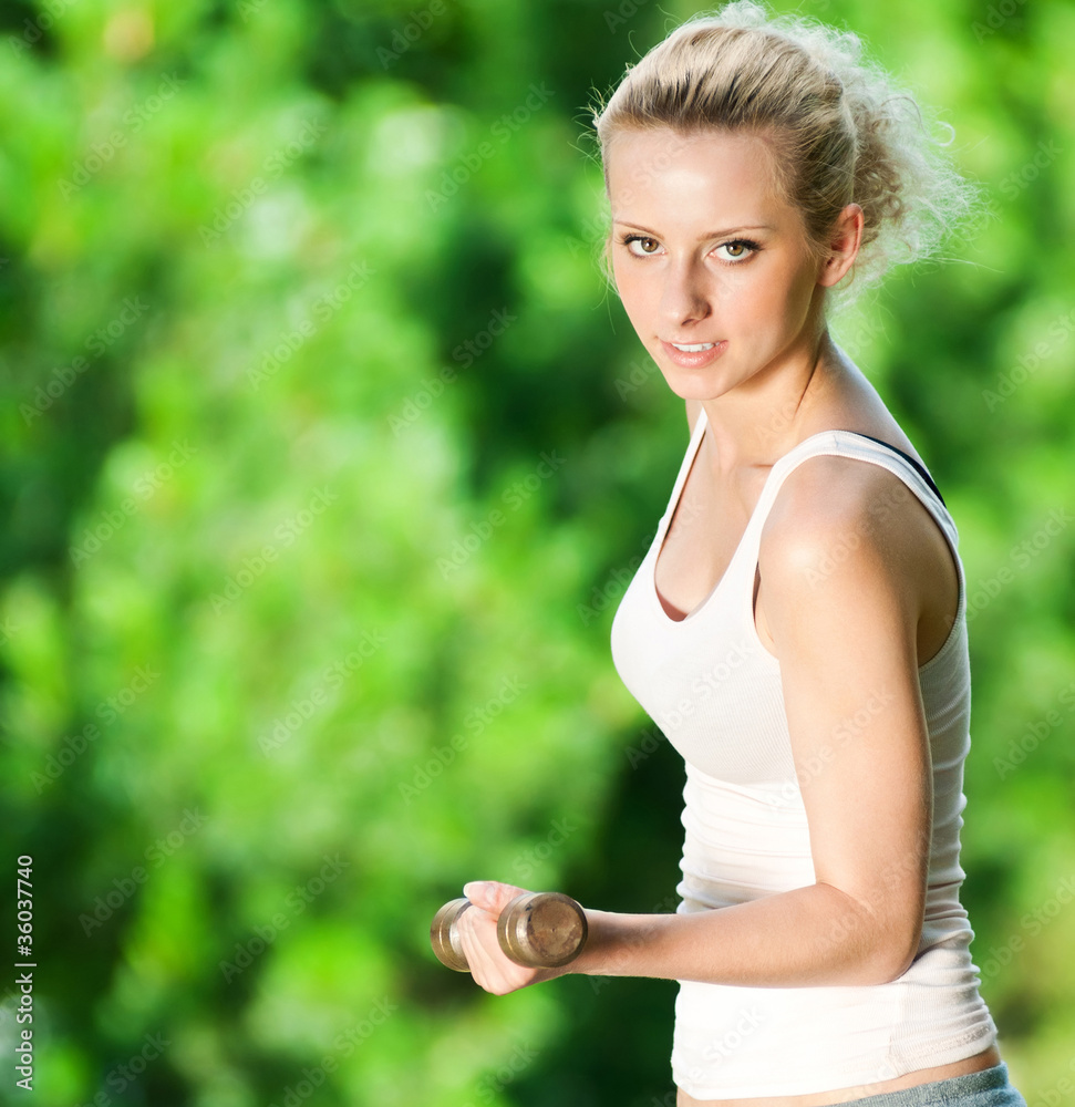 Woman doing dumbbell exercise outdoor Woman doing dumbbell exercise outdoor