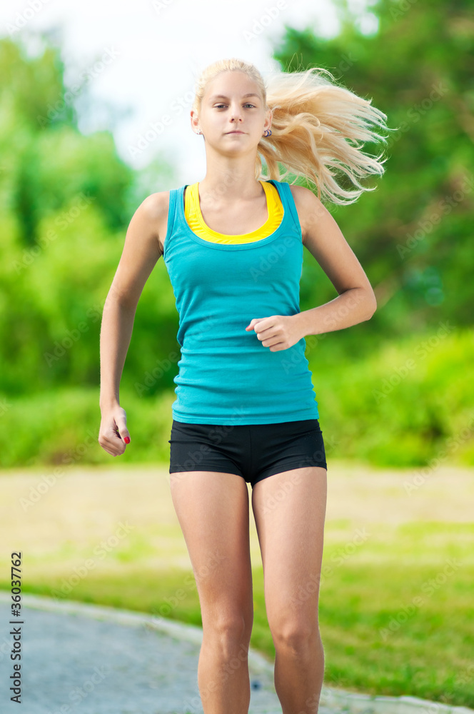 Young woman running in green park Young woman running in green park